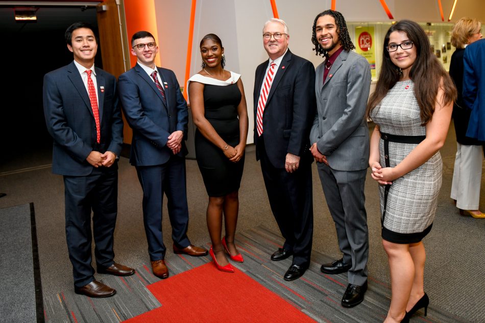 Esmira poses with Chancellor Woodson and four other students